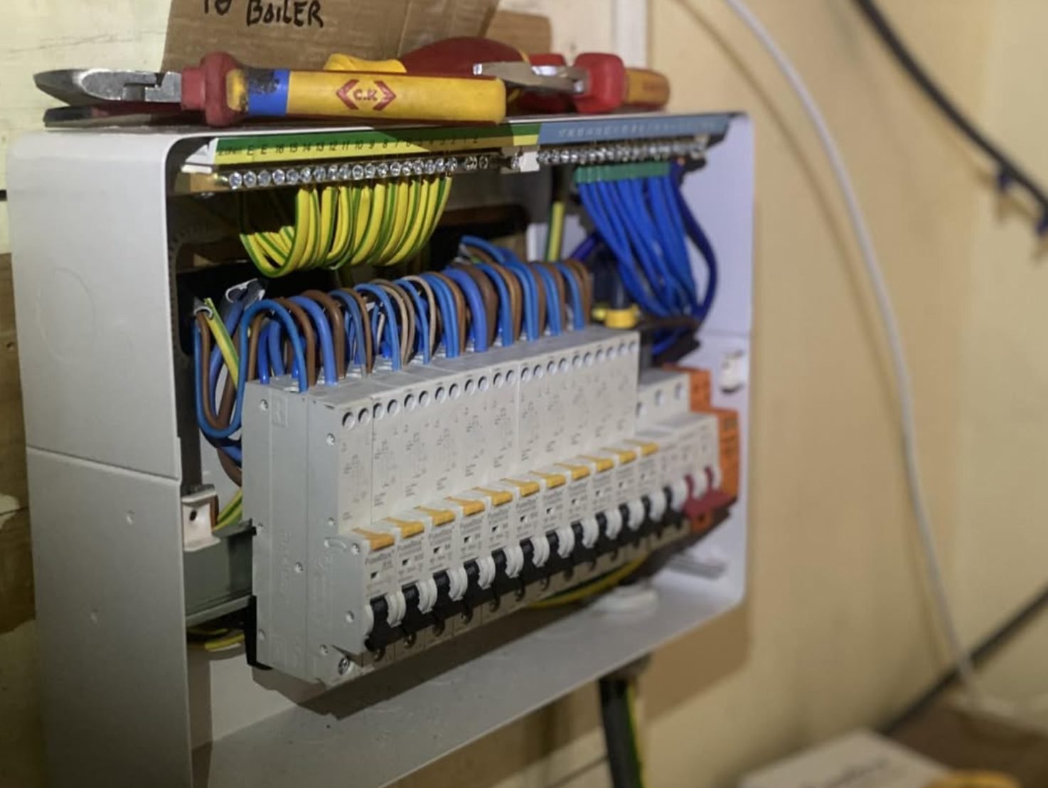 Consumer unit with a full row of RCBOs and neatly dressed cabling